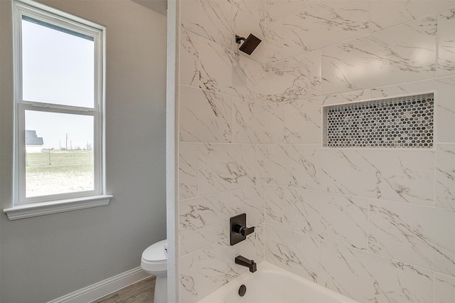 full bathroom featuring tub / shower combination, toilet, baseboards, and wood finished floors