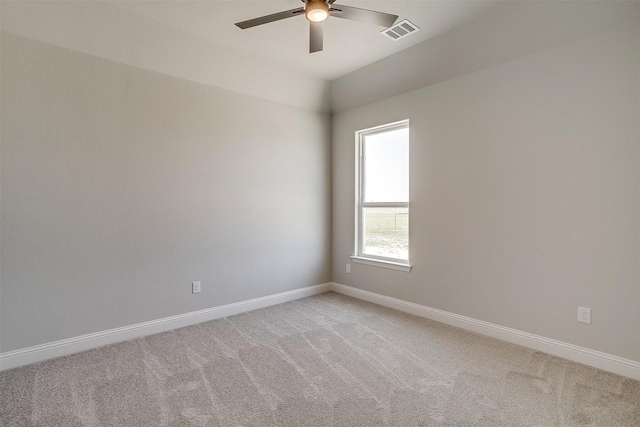 spare room featuring light carpet, visible vents, ceiling fan, and baseboards