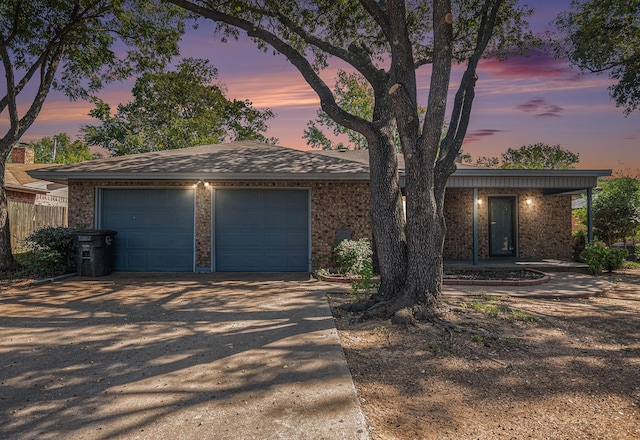 view of front of property featuring a garage, driveway, and fence