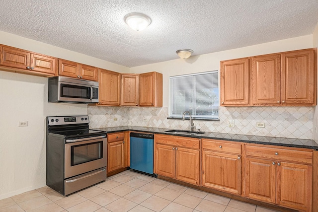 kitchen with a sink, a textured ceiling, decorative backsplash, brown cabinetry, and appliances with stainless steel finishes