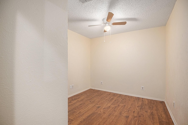 unfurnished room featuring baseboards, a textured ceiling, wood finished floors, and a ceiling fan