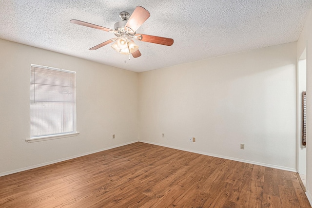 empty room featuring baseboards, a textured ceiling, ceiling fan, and wood finished floors