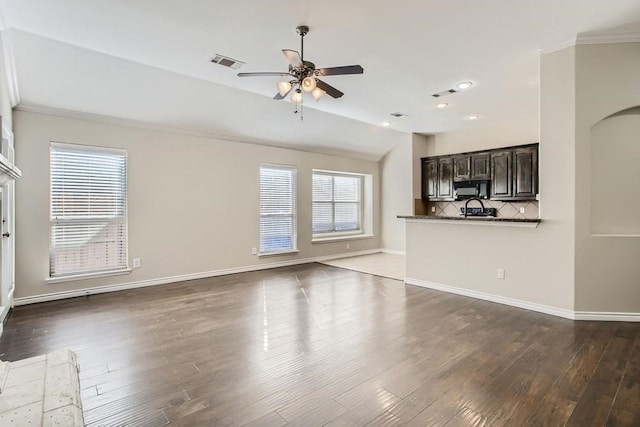 unfurnished living room with dark wood-type flooring, a ceiling fan, visible vents, and baseboards