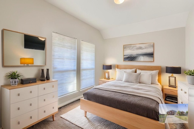 carpeted bedroom featuring baseboards and vaulted ceiling