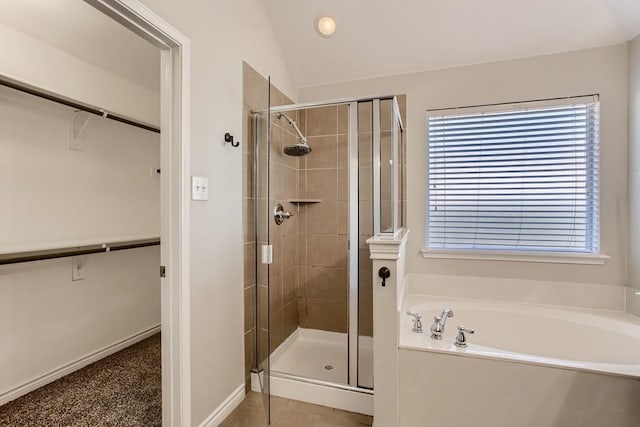 bathroom featuring a spacious closet, a bath, and a stall shower