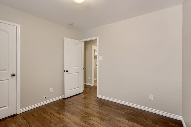 unfurnished bedroom with baseboards and wood finished floors