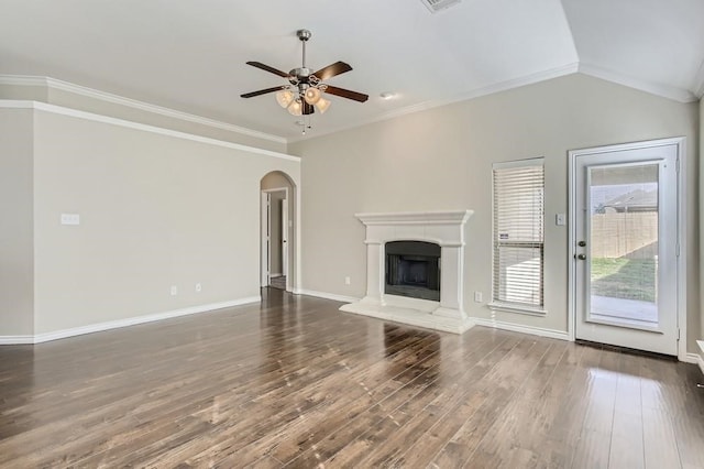 unfurnished living room featuring wood finished floors, a fireplace with raised hearth, arched walkways, and ornamental molding