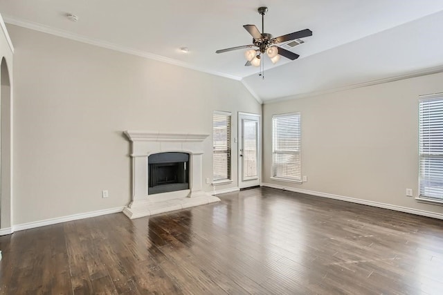 unfurnished living room with a fireplace with raised hearth, ornamental molding, and wood finished floors