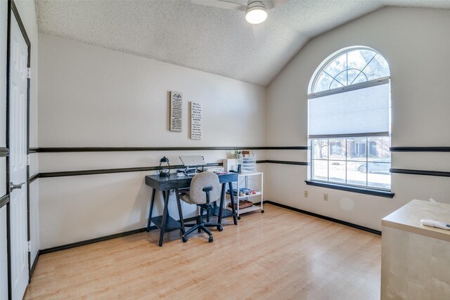 home office featuring a wealth of natural light, lofted ceiling, and a textured ceiling