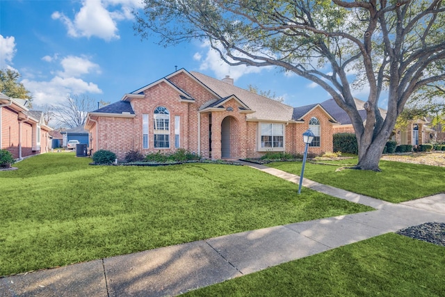 ranch-style house featuring a front lawn, brick siding, roof with shingles, and a chimney