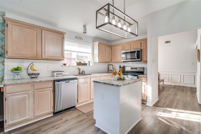 kitchen with visible vents, light wood finished floors, a sink, light brown cabinetry, and stainless steel appliances