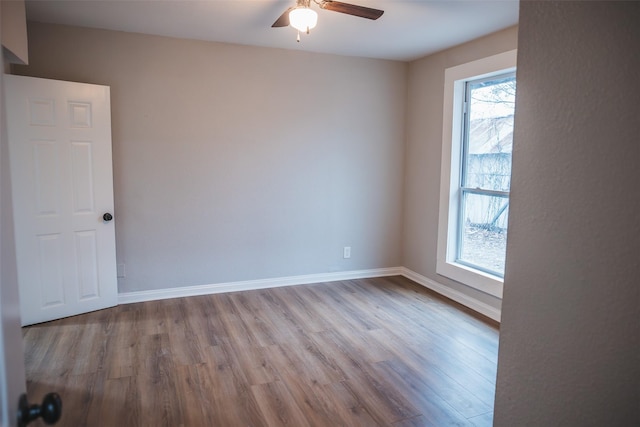 unfurnished room with a ceiling fan, baseboards, and wood finished floors