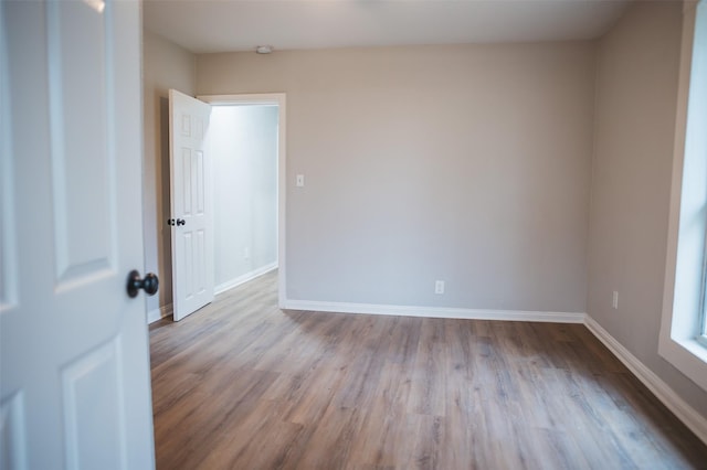 empty room featuring baseboards and wood finished floors