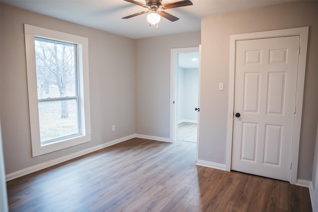 unfurnished room featuring ceiling fan, baseboards, and wood finished floors