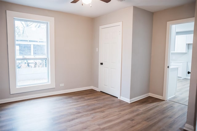 interior space with wood finished floors, baseboards, and ceiling fan