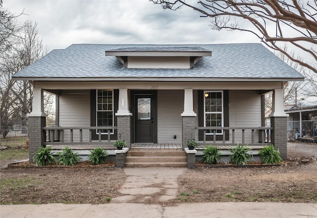 view of front of home featuring covered porch and roof with shingles