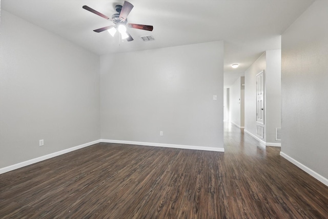 spare room with ceiling fan, dark wood-style floors, visible vents, and baseboards