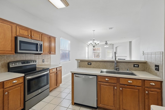 kitchen featuring brown cabinets, stainless steel appliances, and a sink