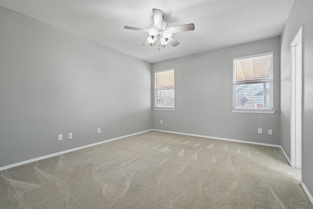 empty room featuring carpet flooring, a ceiling fan, and baseboards