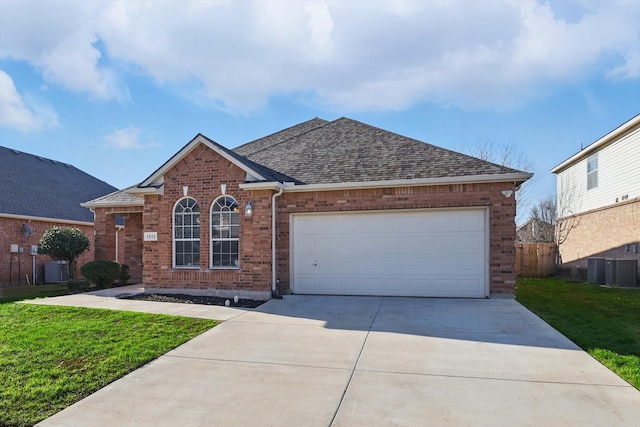 view of front facade with a front lawn, driveway, an attached garage, a shingled roof, and brick siding