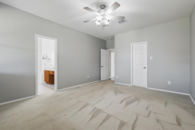 unfurnished bedroom featuring visible vents, baseboards, ensuite bath, ceiling fan, and light colored carpet