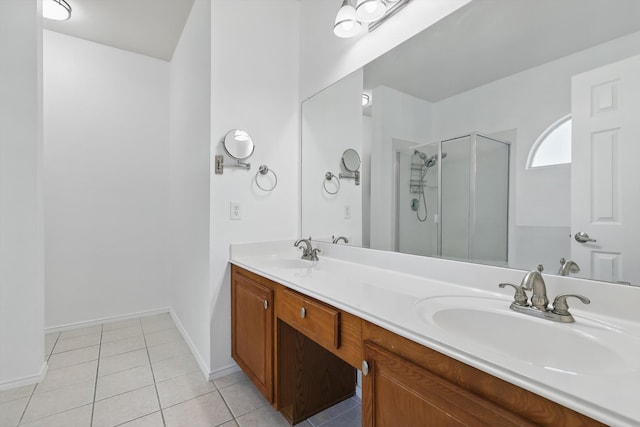 full bathroom featuring tile patterned flooring, a stall shower, double vanity, and a sink