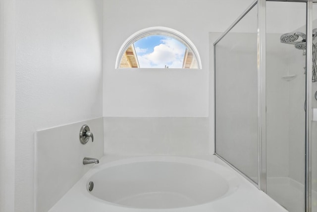 full bathroom featuring a shower stall and a garden tub