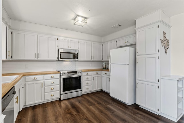 kitchen with visible vents, dark wood-type flooring, white cabinetry, stainless steel appliances, and decorative backsplash