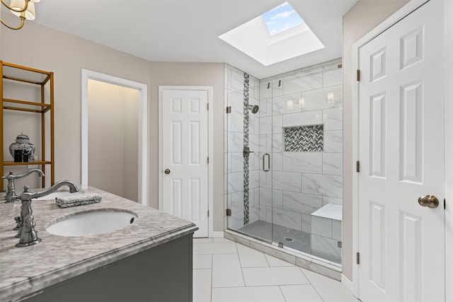 bathroom with tile patterned floors, a closet, a skylight, a shower stall, and vanity