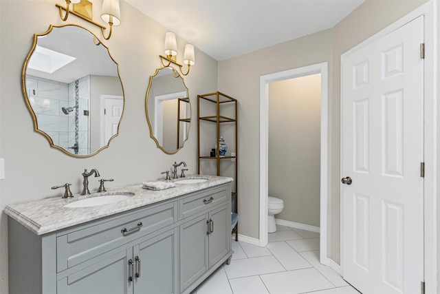 full bath featuring double vanity, toilet, baseboards, and a sink