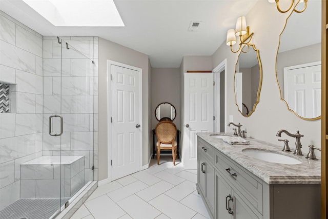 bathroom featuring a shower stall, a skylight, visible vents, and a sink