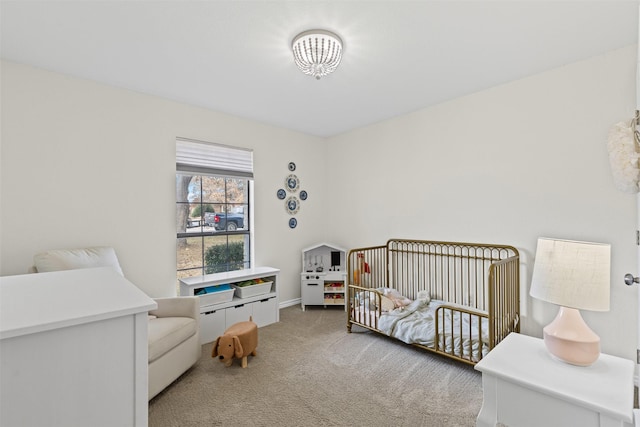 carpeted bedroom featuring a nursery area