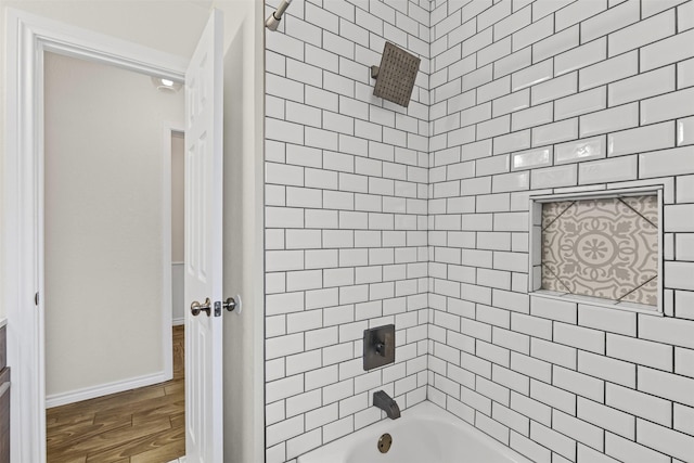 bathroom featuring baseboards, shower / tub combination, and wood finished floors