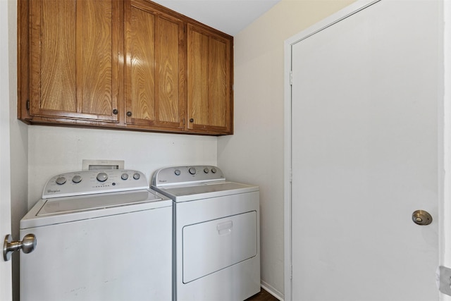 clothes washing area featuring cabinet space and washing machine and dryer