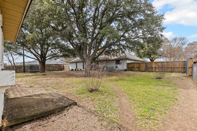 view of yard with a fenced backyard and a trampoline