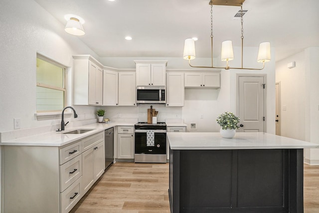 kitchen with light wood-type flooring, visible vents, a sink, appliances with stainless steel finishes, and light countertops