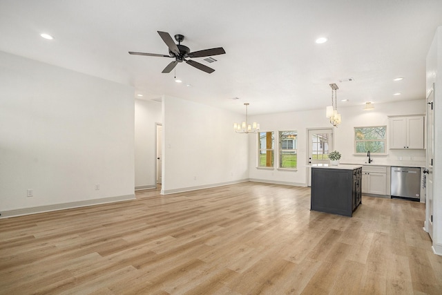 kitchen featuring light wood-style flooring, stainless steel dishwasher, open floor plan, a center island, and light countertops