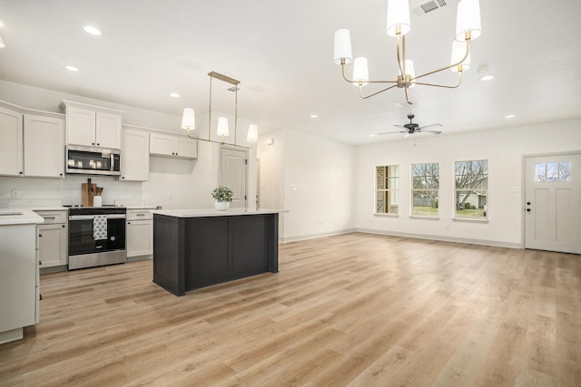 kitchen featuring recessed lighting, appliances with stainless steel finishes, light wood-type flooring, and light countertops