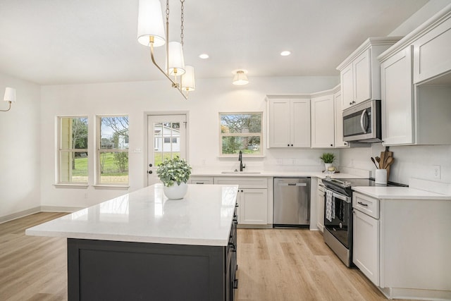 kitchen with a sink, light countertops, a healthy amount of sunlight, and stainless steel appliances