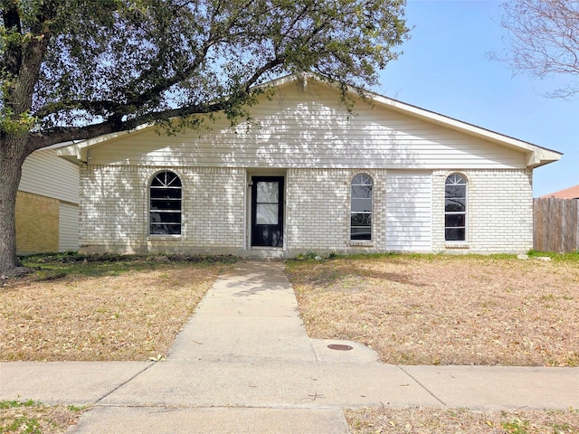 view of front of property featuring brick siding and fence