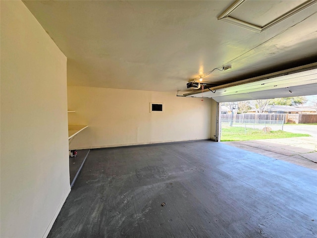 garage featuring a garage door opener and baseboards