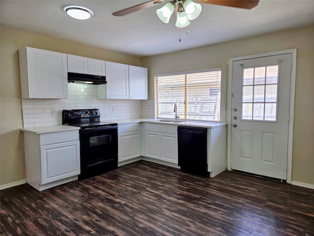 kitchen featuring dark wood-type flooring, black appliances, under cabinet range hood, a sink, and light countertops