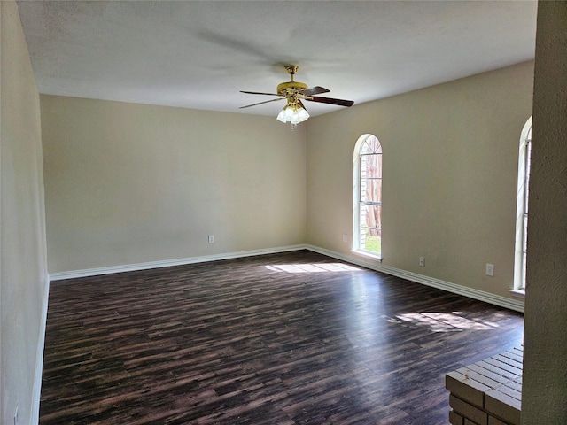 unfurnished room with dark wood-type flooring, baseboards, and ceiling fan