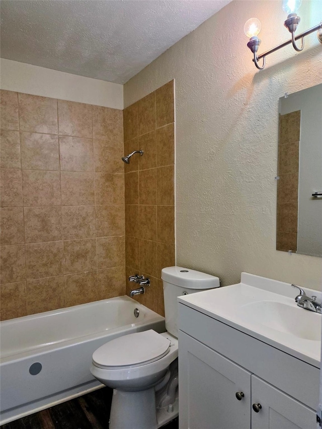 bathroom with vanity, washtub / shower combination, a textured ceiling, toilet, and a textured wall