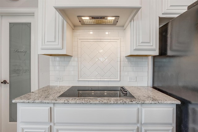 kitchen featuring tasteful backsplash, white cabinetry, ventilation hood, and black electric stovetop