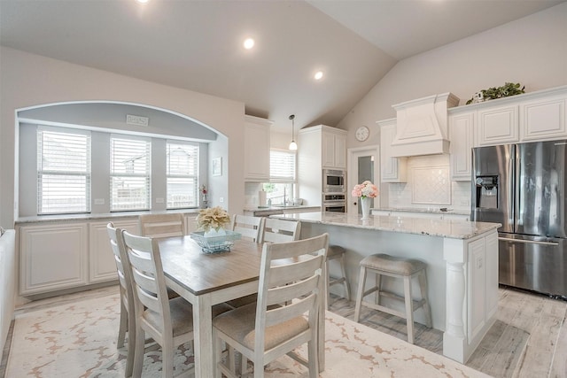 dining area with vaulted ceiling, recessed lighting, and light wood-type flooring