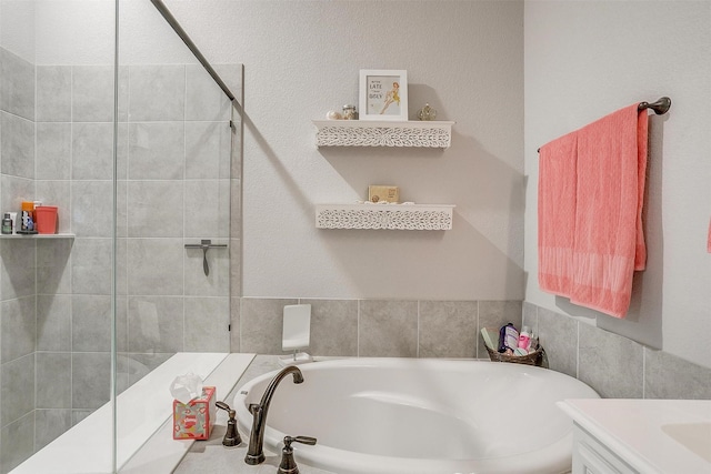 full bathroom featuring a sink, tiled shower, and a garden tub