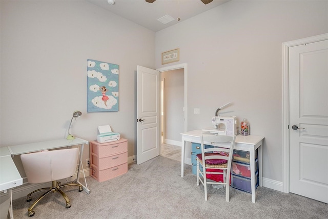 office space with baseboards, light carpet, and ceiling fan