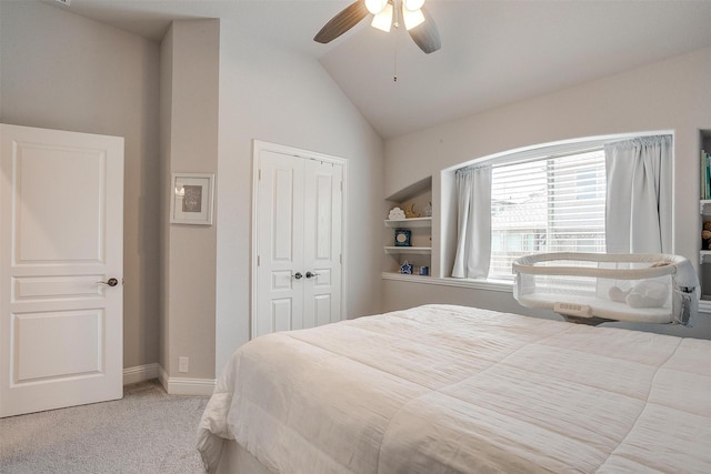 bedroom with baseboards, lofted ceiling, ceiling fan, a closet, and light colored carpet