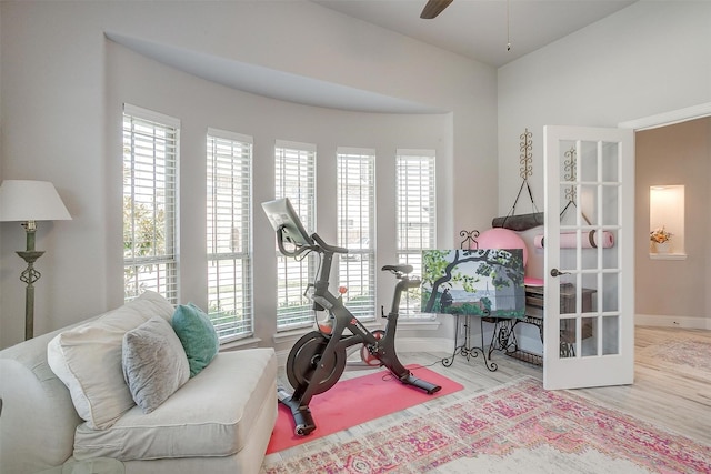 workout area with a healthy amount of sunlight, baseboards, a ceiling fan, and wood finished floors